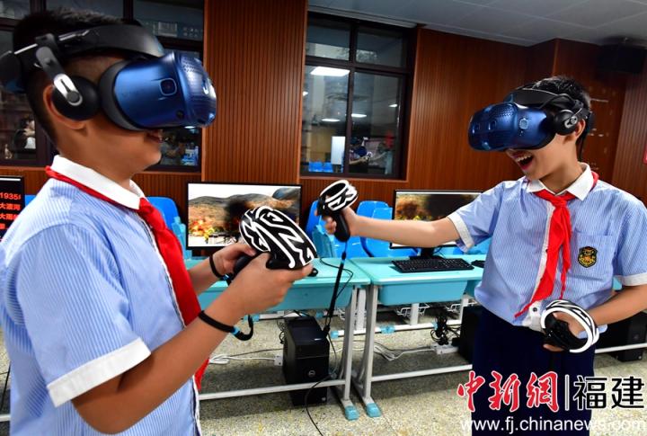 图为小学生戴上VR眼镜直观感受红军战士们的英勇无畏精神。